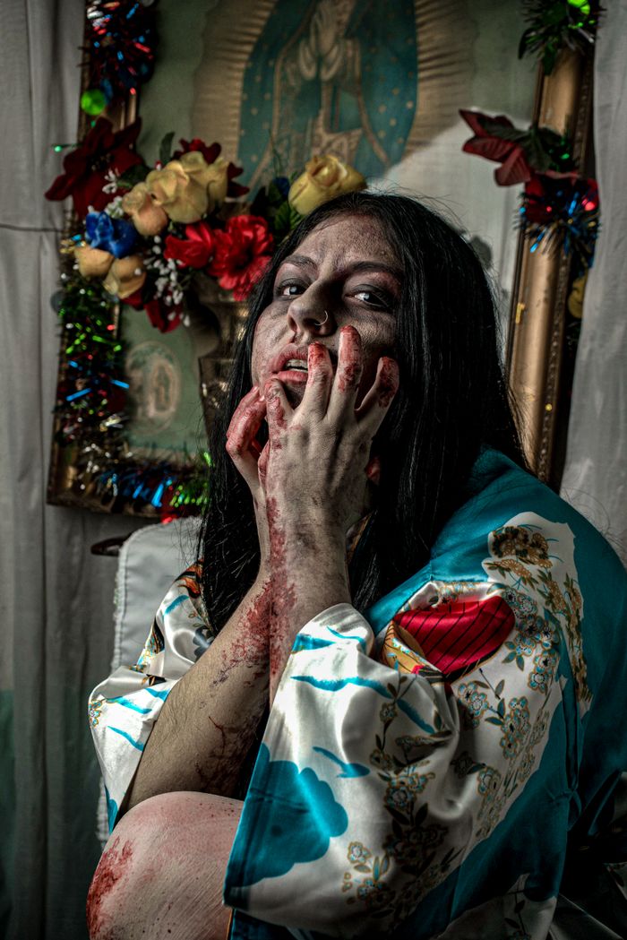 Dramatic horror portrait of a blood-covered woman in a floral robe.