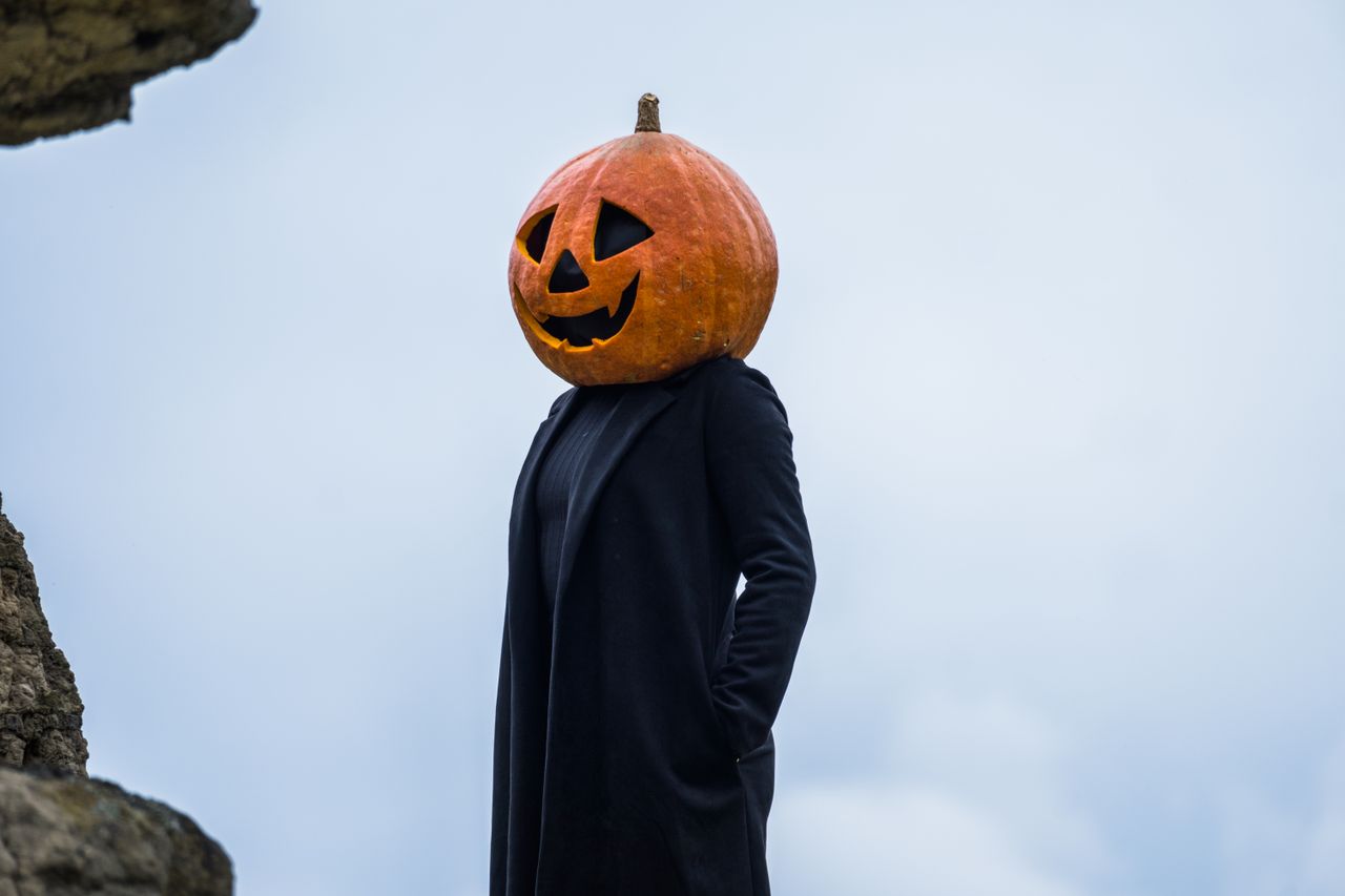 A person in a Halloween pumpkin head costume outdoors in Guasca, Colombia.
